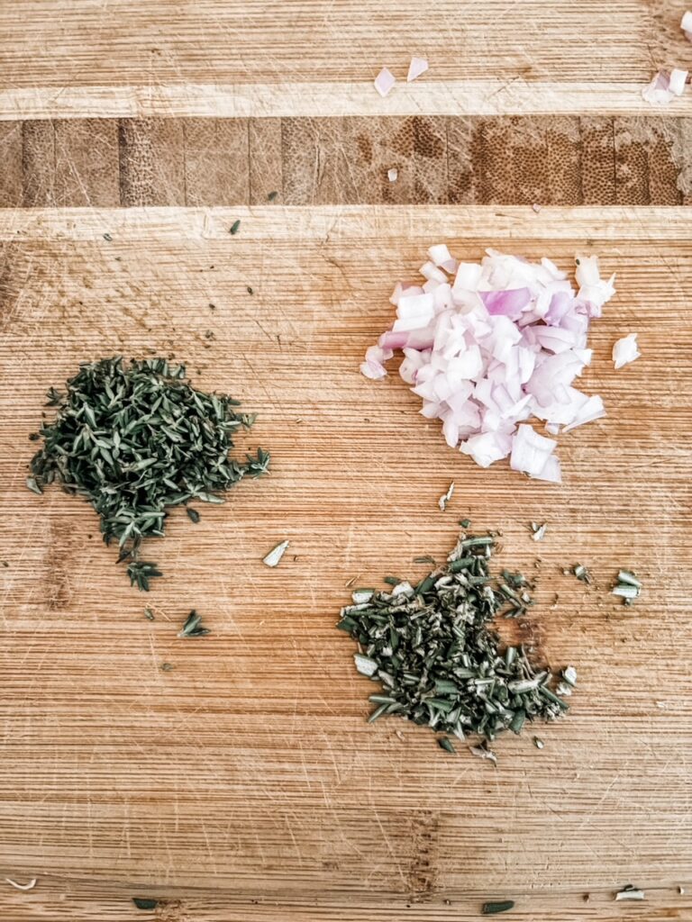 Three piles of minced herbs and onion