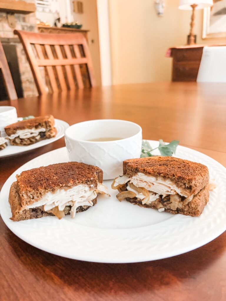 A Chicken French Dip Sandwich cut in half and served on a plate