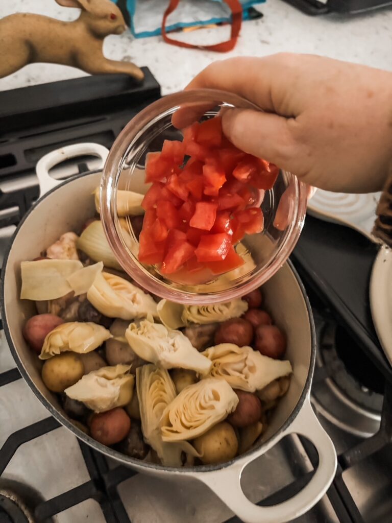 Marie adding the vegetables to the chicken and broth mixture