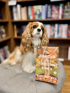 Marie's dog, Showgirl, posing with the book