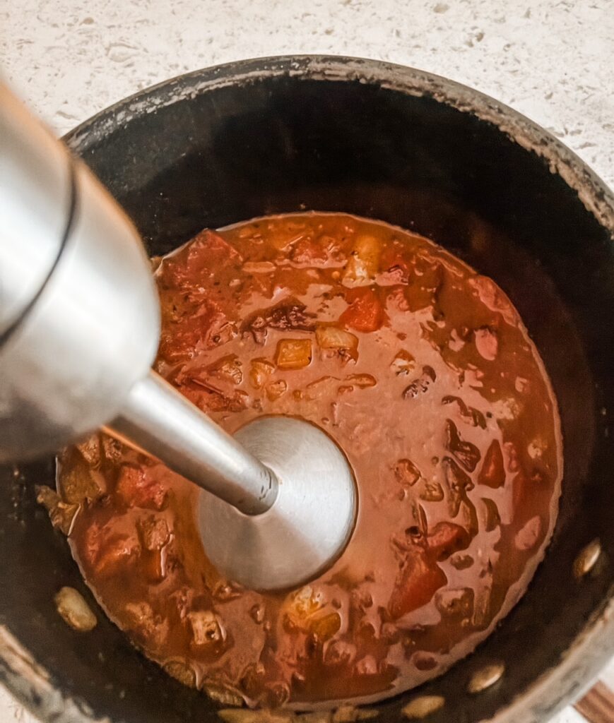 The immersion blender blending the sauce