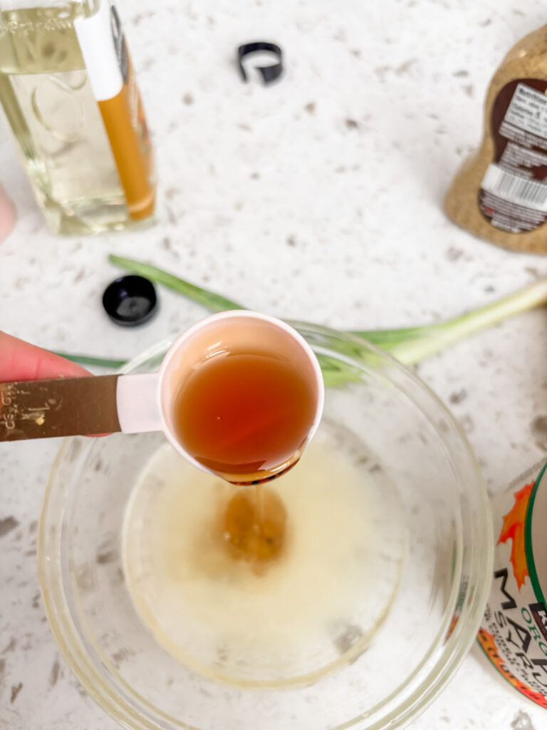 The maple syrup being poured into the lemon juice