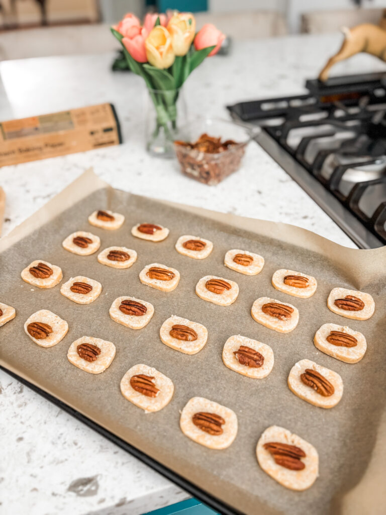 The slices of dough being topped with pecans