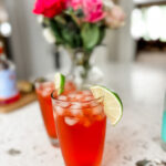 Two of the finished Italian Spritz mocktail garnished with a lime slice