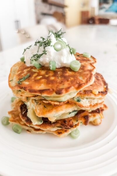 The finished Savory Corn and Zucchini Fritters topped with Greek yogurt