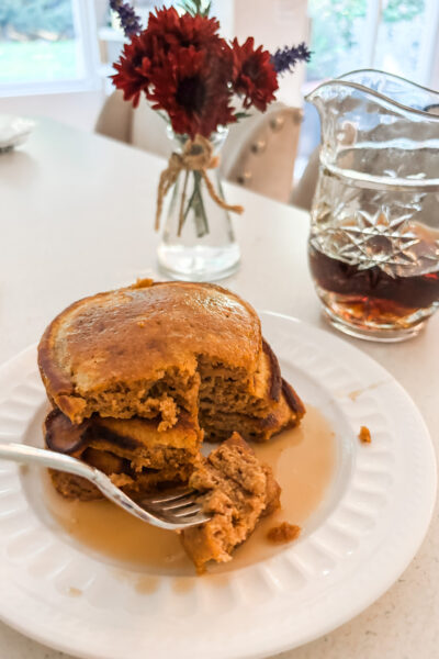 A stack of finished Pumpkin Spice Pancakes with a few bites taken of it