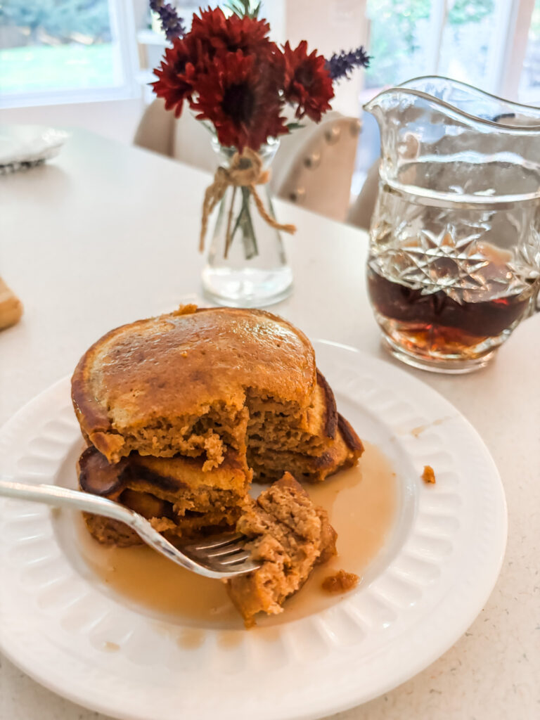 A stack of finished Pumpkin Spice Pancakes with a few bites taken of it