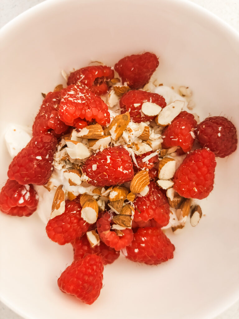A bowl of greek yogurt with berries and protein granola