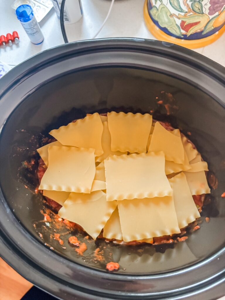 The broken up, no boil lasagna noodles placed in the slow cooker