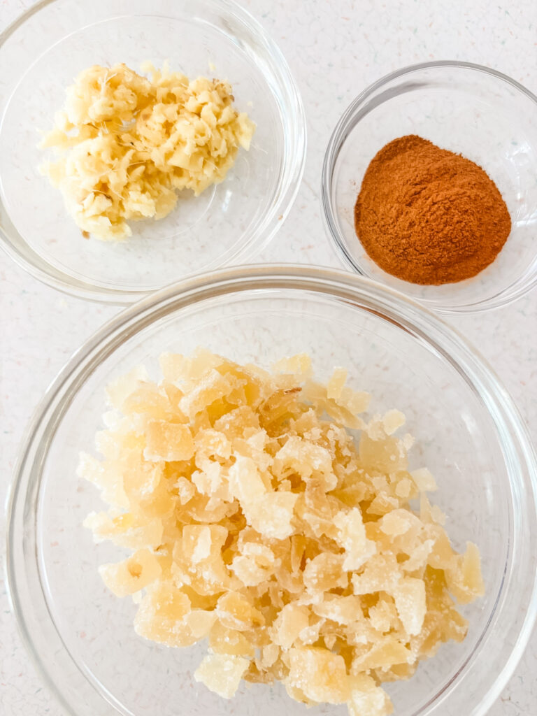 Ingredients for triple ginger molasses cookies laid out on a kitchen counter, including Brer Rabbit molasses, butter, brown sugar, flour, an egg, crystallized ginger, fresh ginger root, cinnamon, and ground ginger
