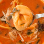 A close up spoonful of the finished creamy tomato tortellini