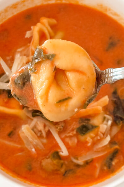 A close up spoonful of the finished creamy tomato tortellini