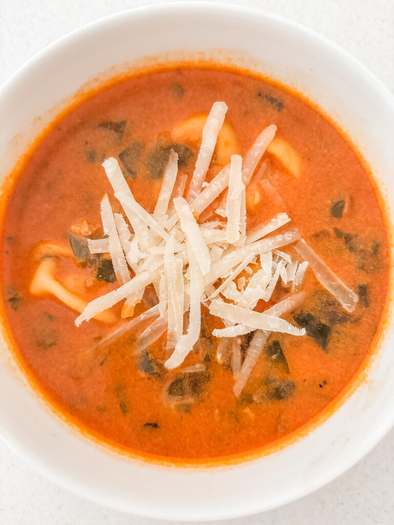 A bowl of the creamy tomato tortellini with grated parmesan on top