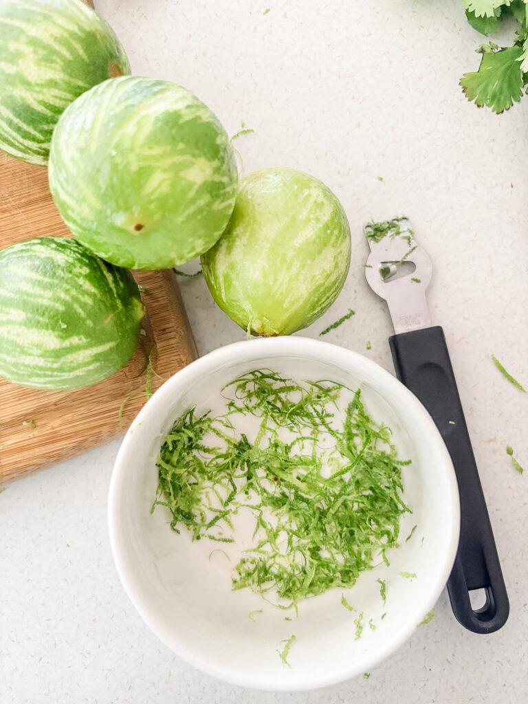 The lime zest in a bowl and the zested limes