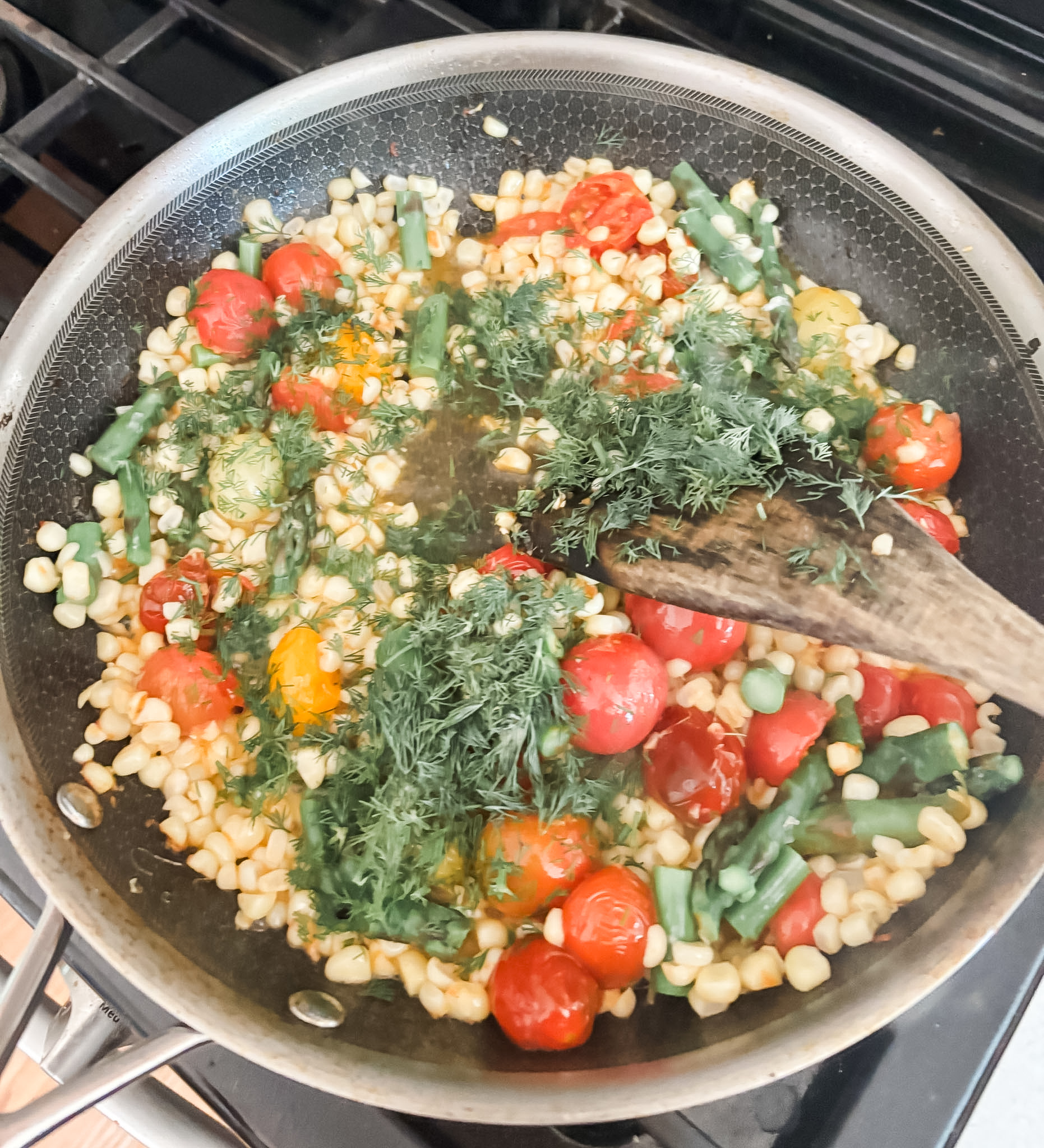 All of the succotash vegetables being cooked together in a pan