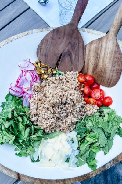 Charlie Bird Salad with farro, shaved parmesan, pistachios, cherry tomatoes, and thinly sliced radishes over arugula and herbs