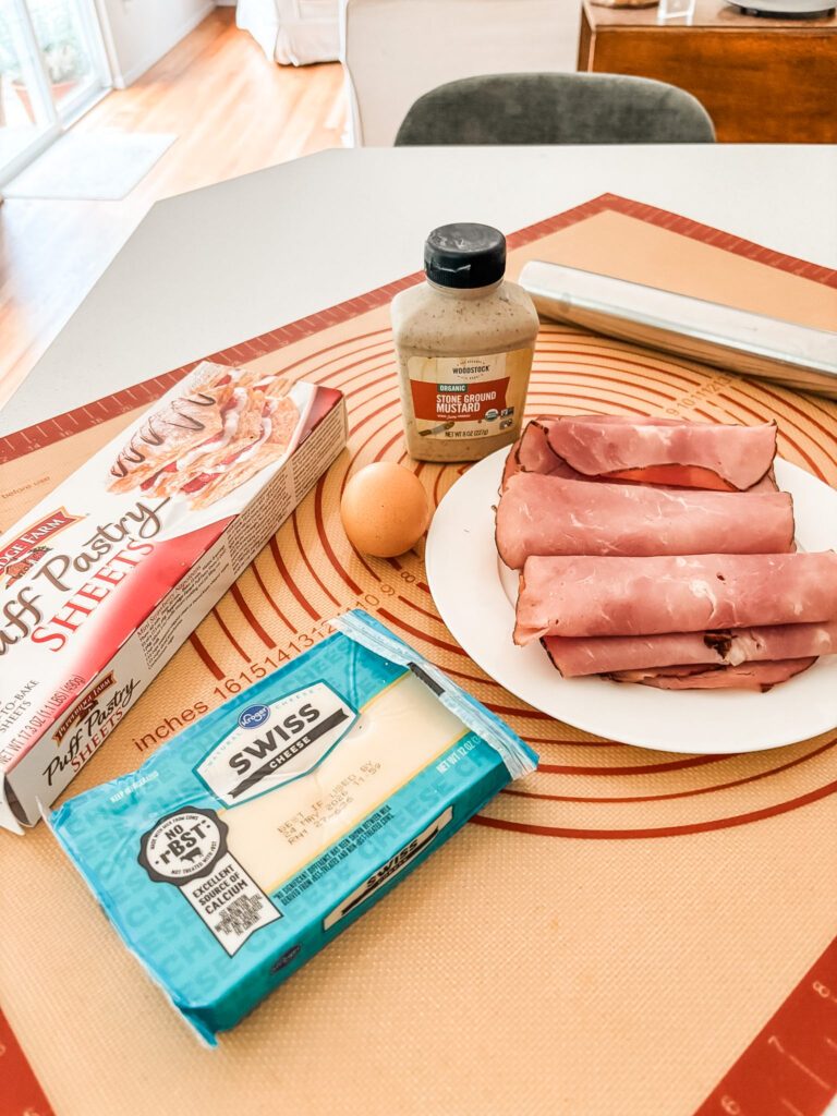 Five ingredients for ham and cheese strudel — puff pastry, deli sliced ham, shredded Swiss cheese, stoneground mustard, and an egg yolk