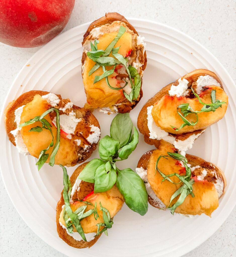 peach crostinis with chèvre, a peach slice, balsamic drizzle, and basil ribbons