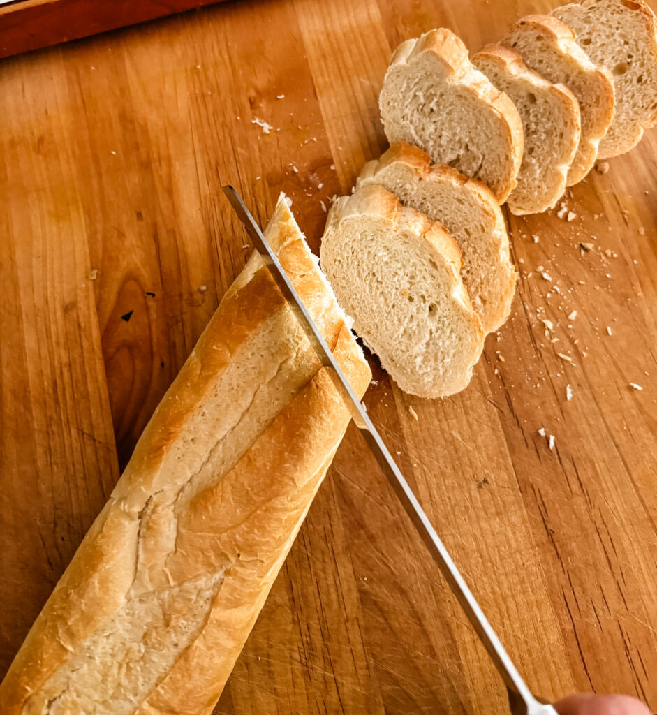 the baguette being sliced diagnolly