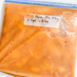Sealed freezer bags of peach pie filling labeled with the date, laid flat for storage
