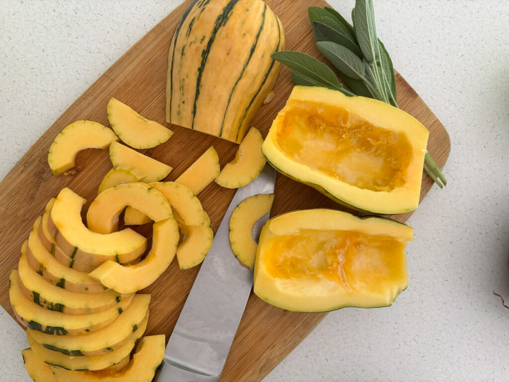 Delicata squash cut into half-moons with the edible skin left on, seeds scooped out
