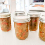 Jars of homemade green tomato sweet relish with diced green tomatoes and red bell peppers