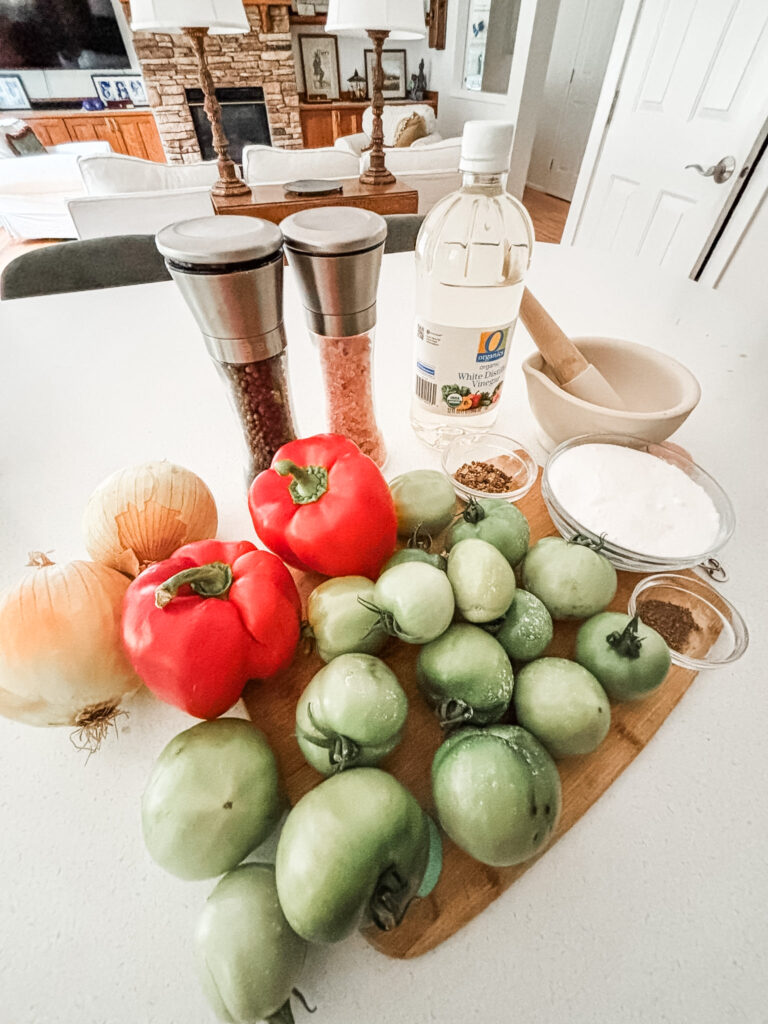Ingredients for green tomato sweet relish including diced green tomatoes, white onion, red bell peppers, white vinegar, sugar, and pickling spices