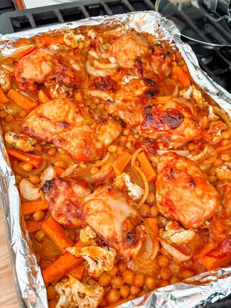 Roasted Mediterranean sheet pan dinner fresh from the oven with charred chicken and caramelized vegetables